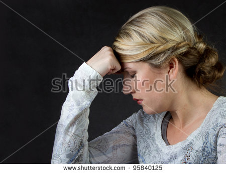 a-woman-deep-in-thought-or-with-a-headache-against-a-dark-background-room-for-copyspace-95840125.jpg