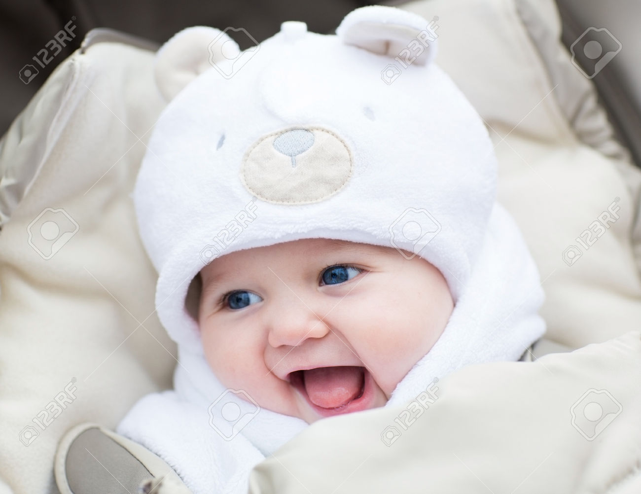 78-Funny-laughing-baby-in-a-teddy-bear-hat-sitting-in-a-stroller-on-c-old-winter-day-Stock-Photo.jpg